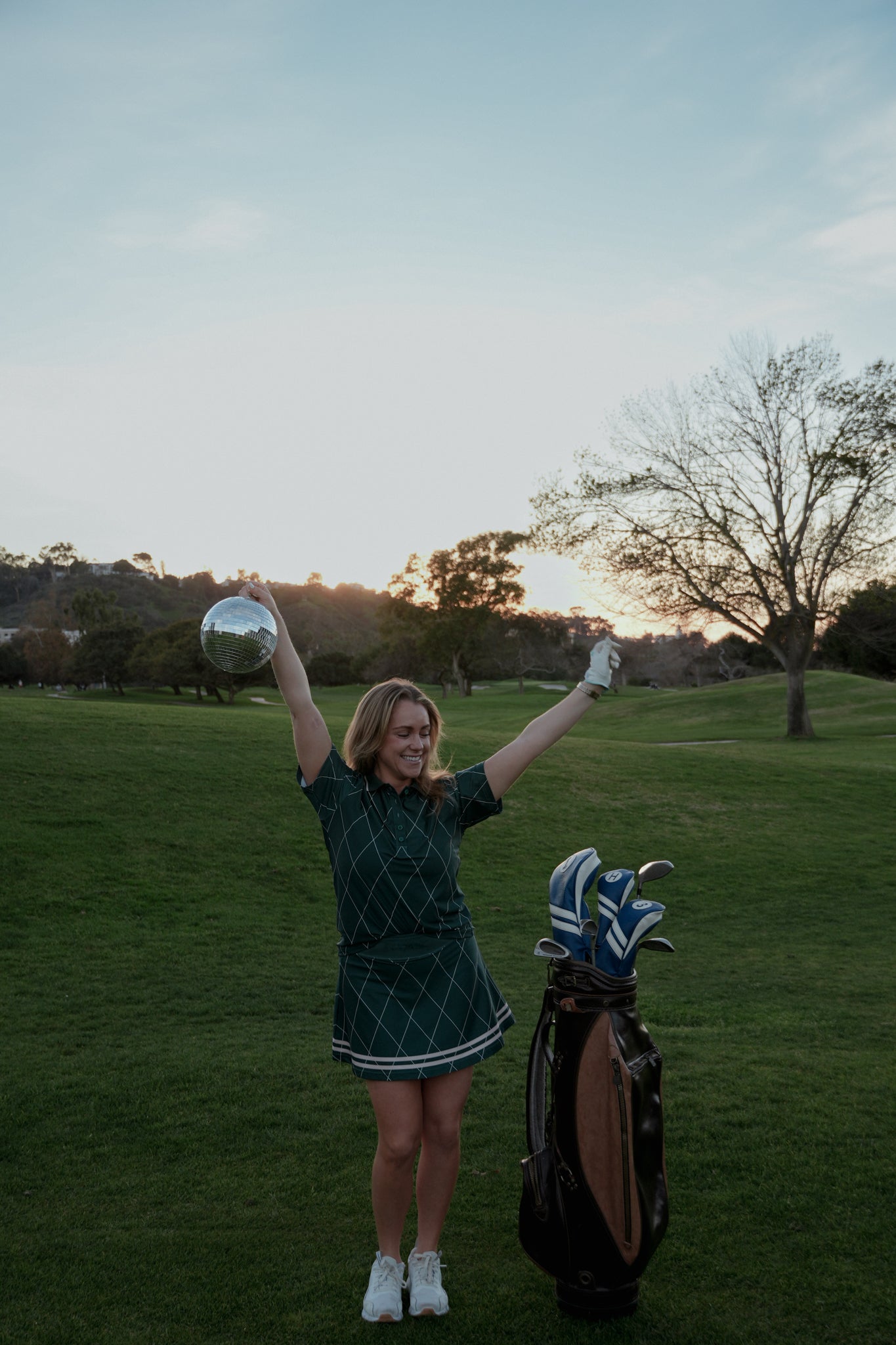 girl holding disco ball on golf course