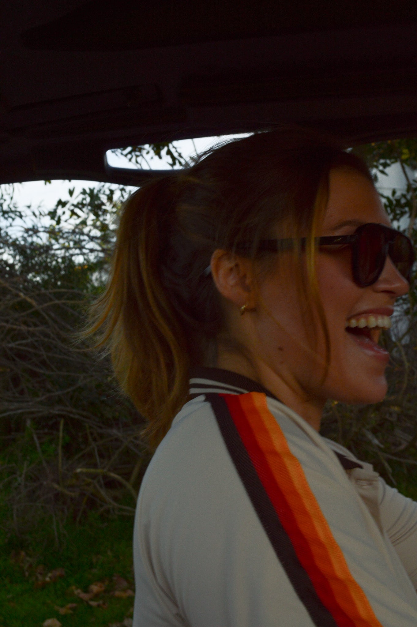 Girl laughing in a golf cart.